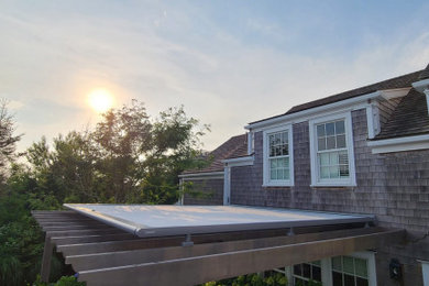 Mid-sized mid-century modern backyard patio photo in Boston with a pergola
