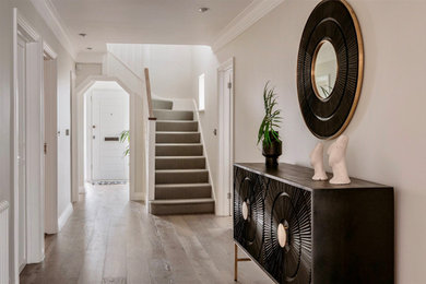 Example of a mid-sized trendy light wood floor hallway design in Hertfordshire with gray walls