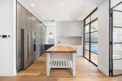 Photo of a transitional kitchen in Melbourne with shaker cabinets.