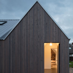 Idee per una piccola porta d'ingresso scandinava con pareti bianche, una porta singola, una porta marrone, pavimento nero e pavimento alla veneziana