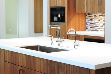 This is an example of a modern kitchen in Dallas with an undermount sink, flat-panel cabinets, brown cabinets, multi-coloured splashback, with island and panelled appliances.