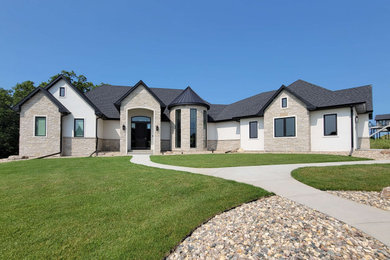 Aménagement d'une grande façade de maison blanche classique à un étage avec un revêtement mixte, un toit à deux pans, un toit mixte et un toit noir.
