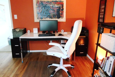 Inspiration for a mid-sized contemporary freestanding desk medium tone wood floor home studio remodel in Detroit with orange walls and no fireplace