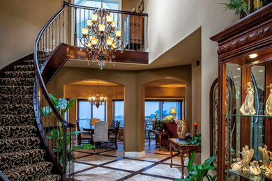 Large mediterranean wood curved staircase in Orange County with wood railing and wood risers.