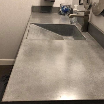 Concrete vanity tops with integrated ramp sinks