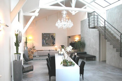 Ejemplo de sala de estar abierta actual extra grande con paredes blancas y suelo de cemento