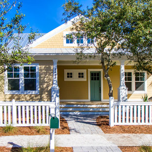 Свежая идея для дизайна: маленький, двухэтажный фасад дома желтого цвета в стиле кантри с облицовкой из дерева и двускатной крышей - отличное фото интерьера