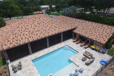 Large traditional one-storey stucco brown exterior in Miami with a gable roof.