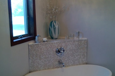 Example of a large trendy master freestanding bathtub design in Other with raised-panel cabinets, white cabinets, a one-piece toilet, beige walls, an undermount sink and quartz countertops