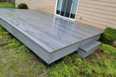 Example of a mid-sized minimalist backyard deck design in Seattle with no cover