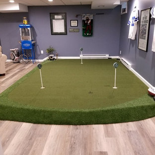 Imagen de sótano en el subsuelo minimalista, grande, con paredes púrpuras y suelo de madera clara