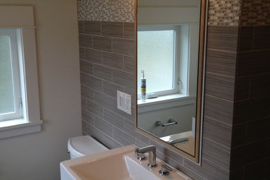 Inspiration for a mid-sized contemporary bathroom in Seattle with an open shower, gray tile, porcelain tile, porcelain floors, a wall-mount sink, grey floor and an open shower.