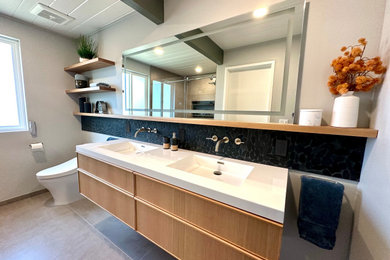 Bathroom - mid-sized contemporary master black tile ceramic tile, gray floor, double-sink and exposed beam bathroom idea in San Francisco with flat-panel cabinets, light wood cabinets, a one-piece toilet, gray walls, an integrated sink, solid surface countertops, white countertops and a floating vanity