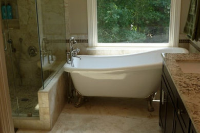 Example of a trendy master beige tile and porcelain tile porcelain tile bathroom design in Raleigh with an undermount sink, dark wood cabinets, granite countertops, an undermount tub and beige walls