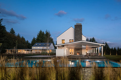 Huge trendy backyard stone and rectangular hot tub photo in Other