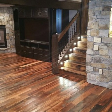 Antique Skip Oak Flooring in a Lower Level with Stone Fireplace