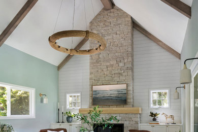 Example of a large transitional light wood floor, beige floor, vaulted ceiling and shiplap wall living room design in San Francisco with blue walls, a standard fireplace and a stone fireplace