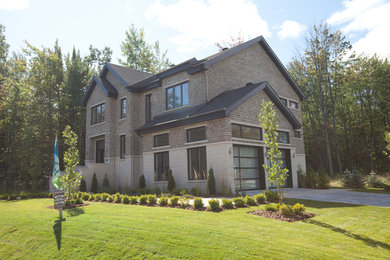 Inspiration for a large contemporary gray two-story brick gable roof remodel in Montreal