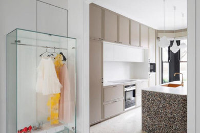 Ejemplo de cocina contemporánea con armarios con paneles empotrados, puertas de armario beige, salpicadero blanco y una isla