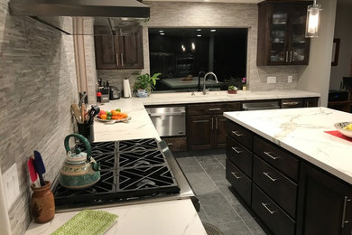 Photo of a large contemporary l-shaped kitchen pantry with an undermount sink, solid surface benchtops, stainless steel appliances and with island.
