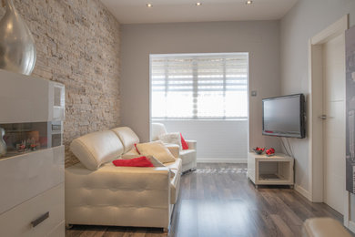 Imagen de salón cerrado clásico renovado de tamaño medio con paredes grises, suelo vinílico, televisor colgado en la pared, suelo gris, piedra y cortinas