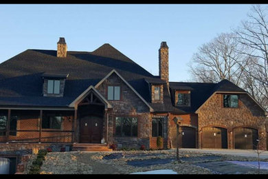 Mountain style brown three-story brick exterior home photo in Other