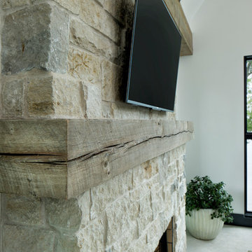 Weathered Antique Mantel on Stacked Stone Fireplace in Transitional Living Room