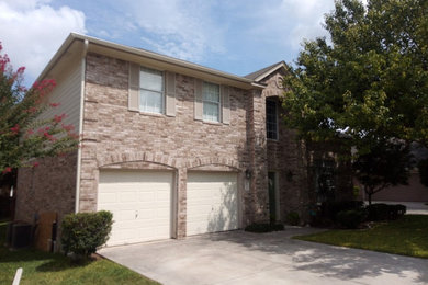 Example of a mid-sized trendy red two-story brick exterior home design in Austin with a tile roof