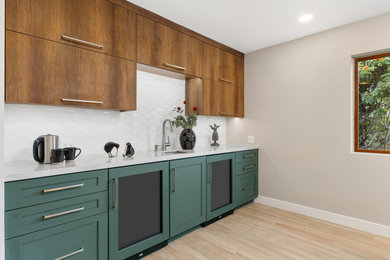 Wet bar - mid-sized modern single-wall porcelain tile wet bar idea in San Diego with flat-panel cabinets, green cabinets, quartz countertops, white backsplash and white countertops