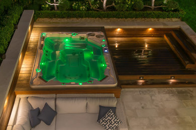 This is an example of a contemporary pool in New York with a hot tub.