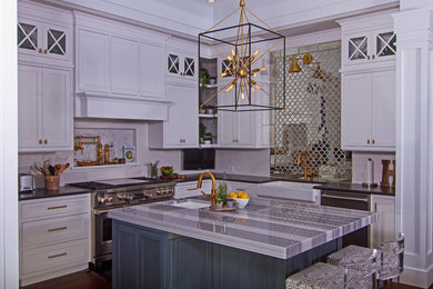 Inspiration for a mid-sized 1950s medium tone wood floor and brown floor open concept kitchen remodel in Tampa with a farmhouse sink, shaker cabinets, white cabinets, marble countertops, white backsplash, subway tile backsplash, stainless steel appliances, an island and multicolored countertops