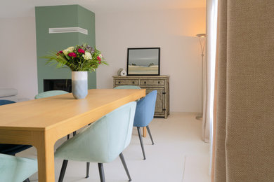 Inspiration pour une salle à manger design avec un mur beige, un sol en carrelage de céramique, une cheminée standard, un sol beige et éclairage.