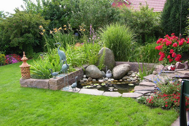 Geometrischer, Großer Mediterraner Gartenteich im Sommer, hinter dem Haus mit Natursteinplatten und direkter Sonneneinstrahlung in Frankfurt am Main