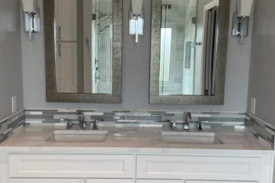 Example of a mid-sized transitional master gray tile and porcelain tile porcelain tile, gray floor, double-sink and vaulted ceiling bathroom design in Cincinnati with recessed-panel cabinets, white cabinets, an undermount sink, quartz countertops, a hinged shower door, white countertops and a built-in vanity