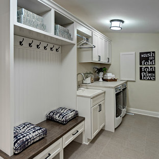 Small rural single-wall utility room in Minneapolis with a built-in sink, white cabinets, laminate countertops, beige walls, porcelain flooring, a side by side washer and dryer and recessed-panel cabinets.
