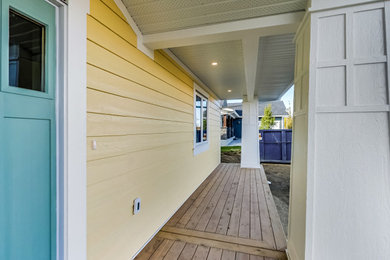 Modelo de fachada de casa amarilla y gris de estilo americano de dos plantas con revestimiento de madera, tejado a dos aguas, tejado de teja de madera y panel y listón