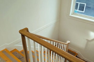 Transitional wooden u-shaped wood railing staircase photo in Vancouver with wooden risers