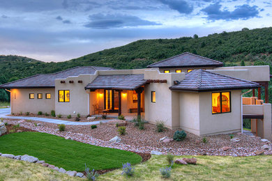 Design ideas for a transitional one-storey adobe beige exterior in Denver with a hip roof.