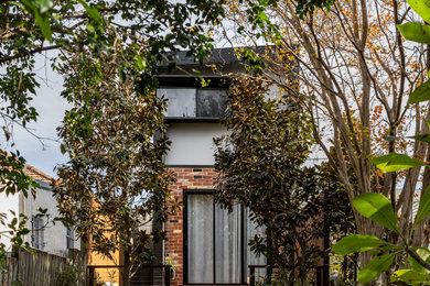 Ejemplo de fachada de casa gris y gris moderna de tamaño medio de dos plantas con revestimiento de ladrillo, tejado a dos aguas, tejado de metal y panel y listón