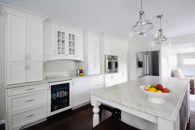 Large elegant l-shaped dark wood floor and brown floor eat-in kitchen photo in New York with an undermount sink, flat-panel cabinets, white cabinets, quartzite countertops, beige backsplash, stone slab backsplash, stainless steel appliances, an island and beige countertops