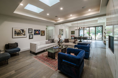 Example of an eclectic formal and open concept medium tone wood floor, brown floor and tray ceiling living room design in San Francisco with white walls, a standard fireplace and a stone fireplace