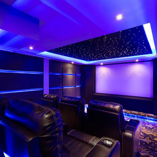 Réalisation d'une petite salle de cinéma minimaliste fermée avec un mur noir, moquette, un écran de projection et un sol bleu.