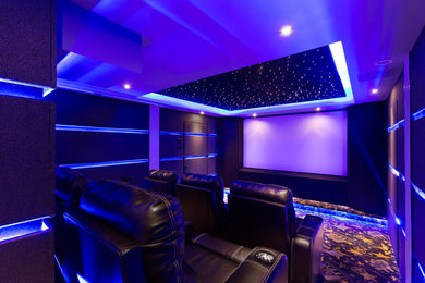 Small minimalist enclosed carpeted home theater photo in DC Metro with black walls and a projector screen