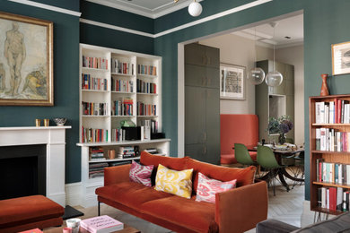 This is an example of a large classic formal open plan living room in London with blue walls, light hardwood flooring, a standard fireplace, a plastered fireplace surround, a corner tv and a dado rail.