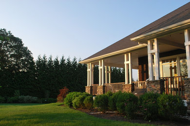 Photo of a mid-sized transitional full sun backyard stone landscaping in Providence for summer.