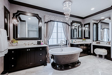 Photo of a large transitional master wet room bathroom in Orange County with recessed-panel cabinets, black cabinets, a freestanding tub, white tile, stone slab, marble benchtops, a two-piece toilet, grey walls, marble floors, an undermount sink, white floor and a hinged shower door.