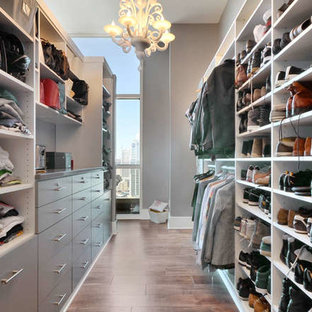 Large trendy gender-neutral porcelain tile and brown floor walk-in closet photo in Austin with gray cabinets