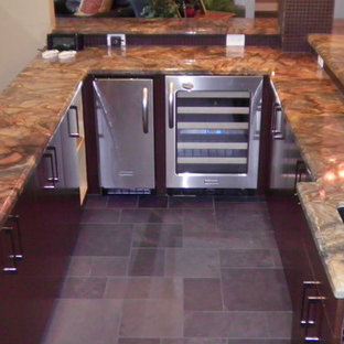 ヒューストンの中サイズのトラディショナルスタイルのおしゃれな着席型バー (アンダーカウンターシンク、フラットパネル扉のキャビネット、濃色木目調キャビネット、茶色いキッチンパネル、グレーの床) の写真