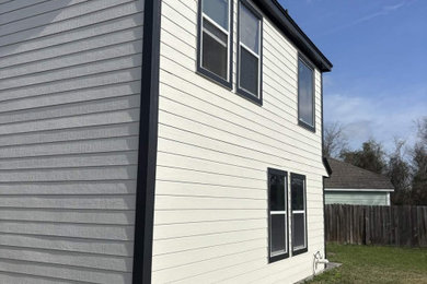 Inspiration for a mid-sized modern white two-story adobe and clapboard house exterior remodel in Houston