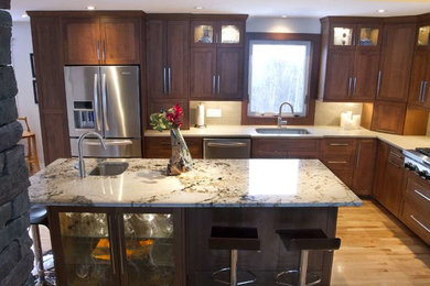 Example of a mid-sized transitional l-shaped light wood floor and beige floor open concept kitchen design in Other with an undermount sink, shaker cabinets, dark wood cabinets, quartz countertops, beige backsplash, porcelain backsplash, stainless steel appliances and an island